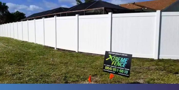 white vinyl fence with an Xtreme Fence sign in front